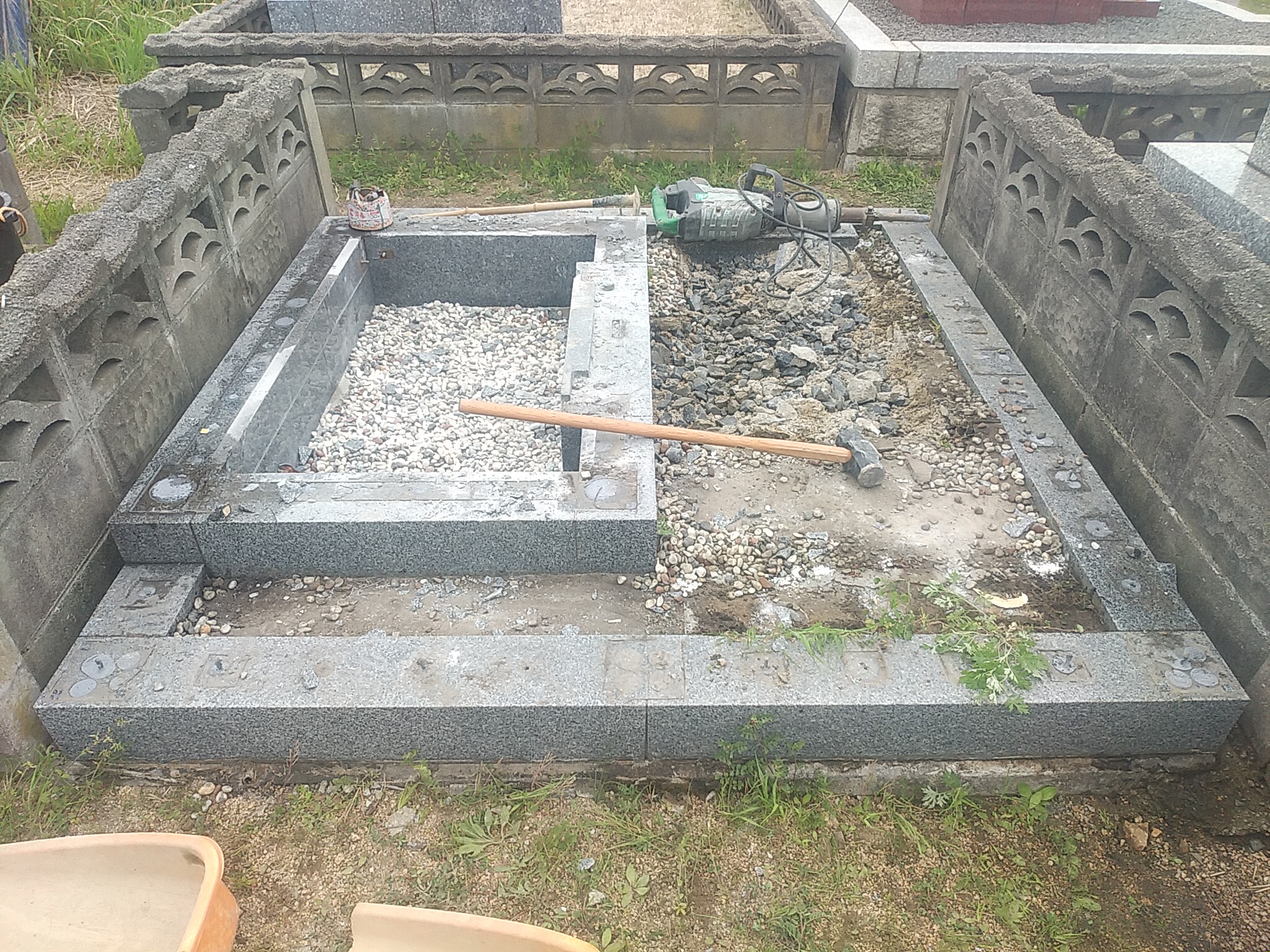 お墓の囲いである巻石や四ツ石の解体作業