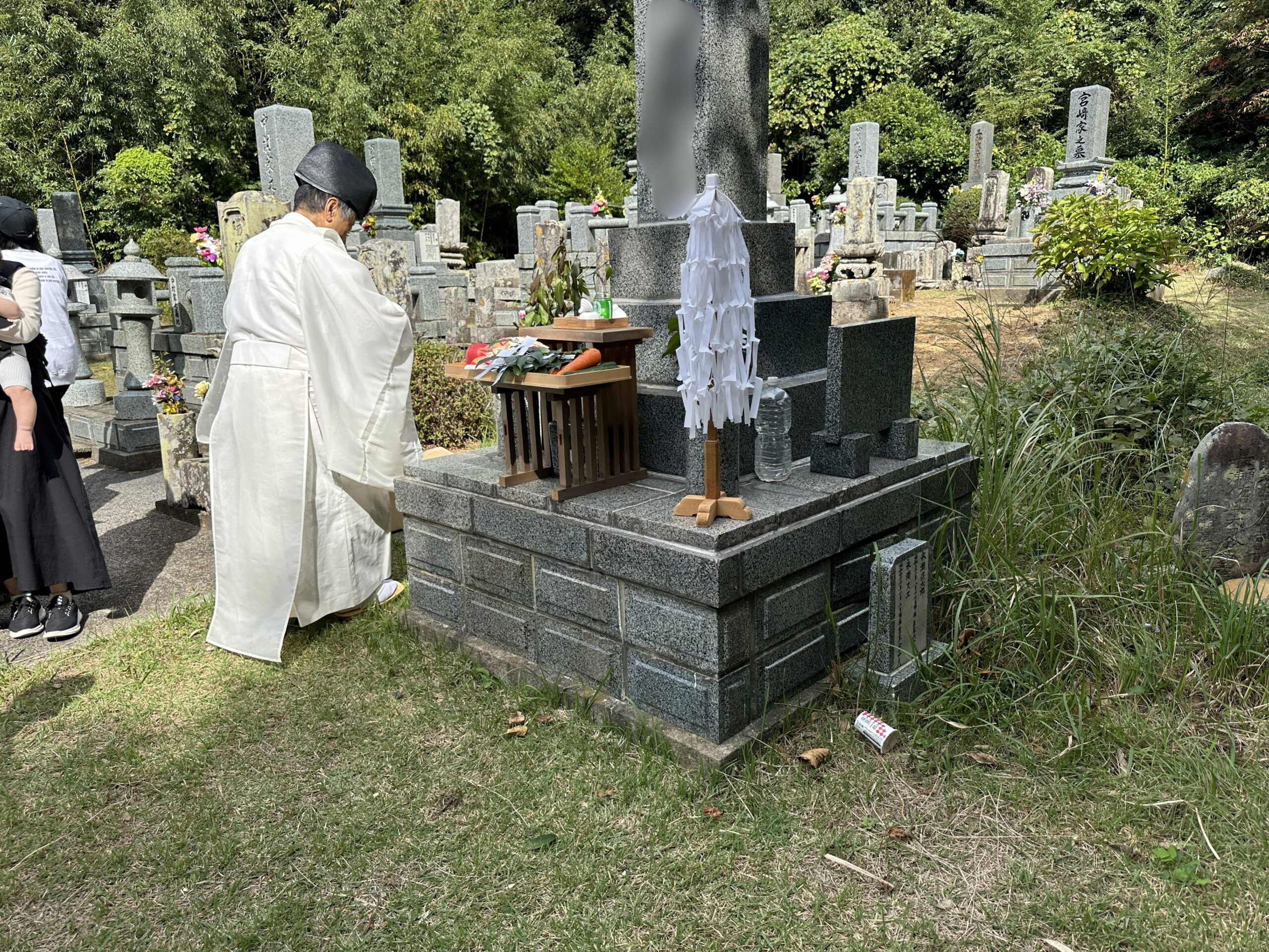 お墓に向かって真摯に祈りを奉げる神主の姿